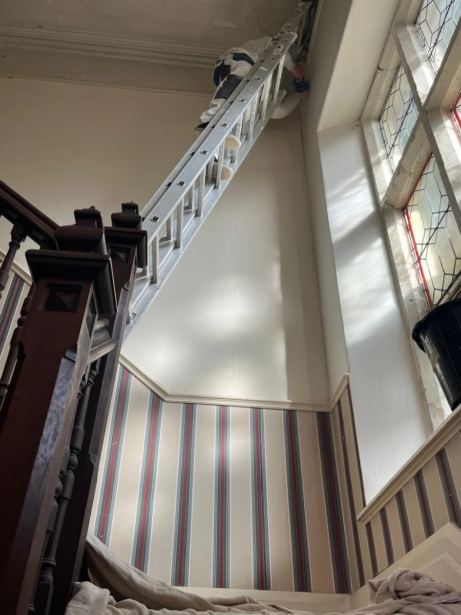 Ladder work in a double-height stairwell, Swansea hallway