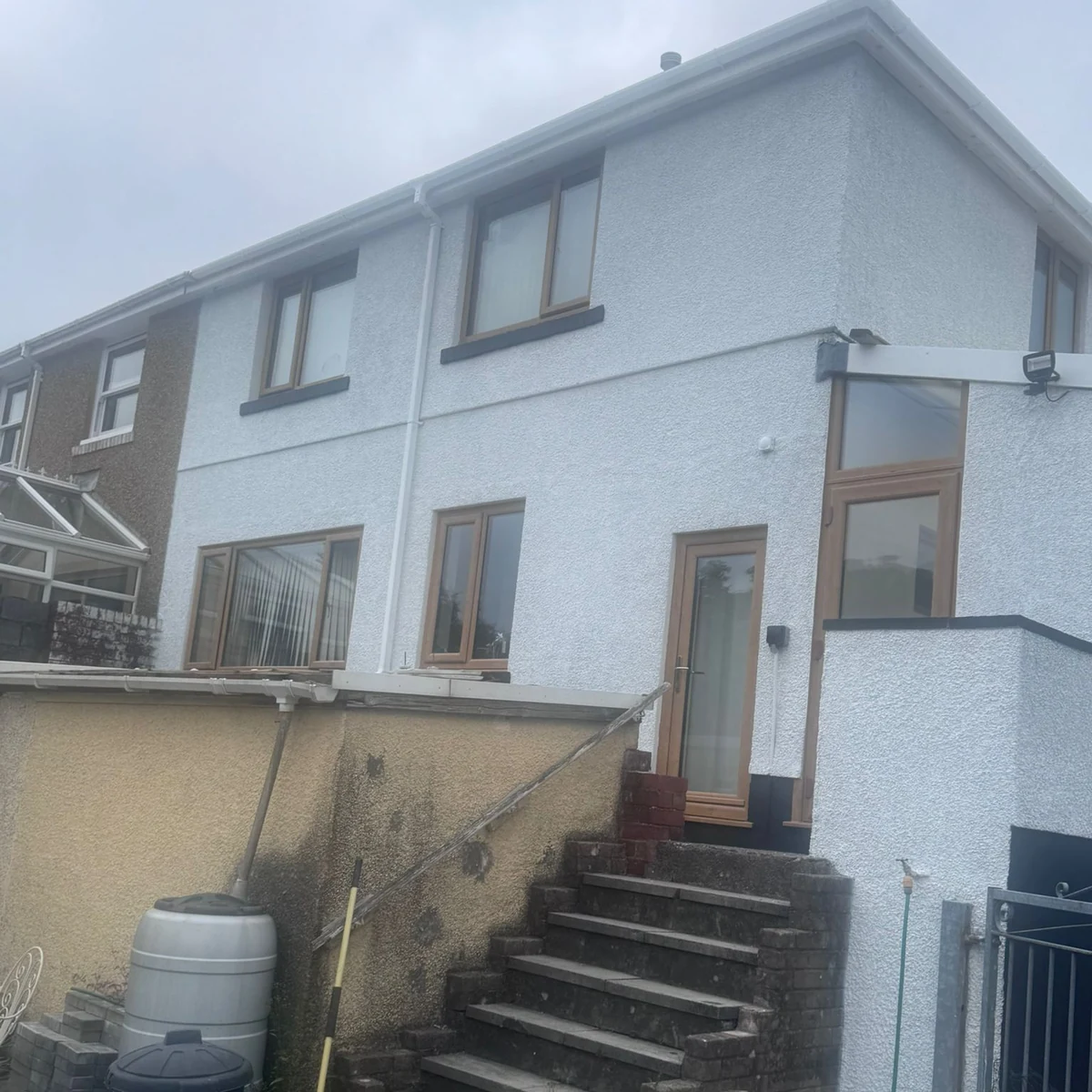 Rear elevation after a complete house repaint, decorators covering Newton