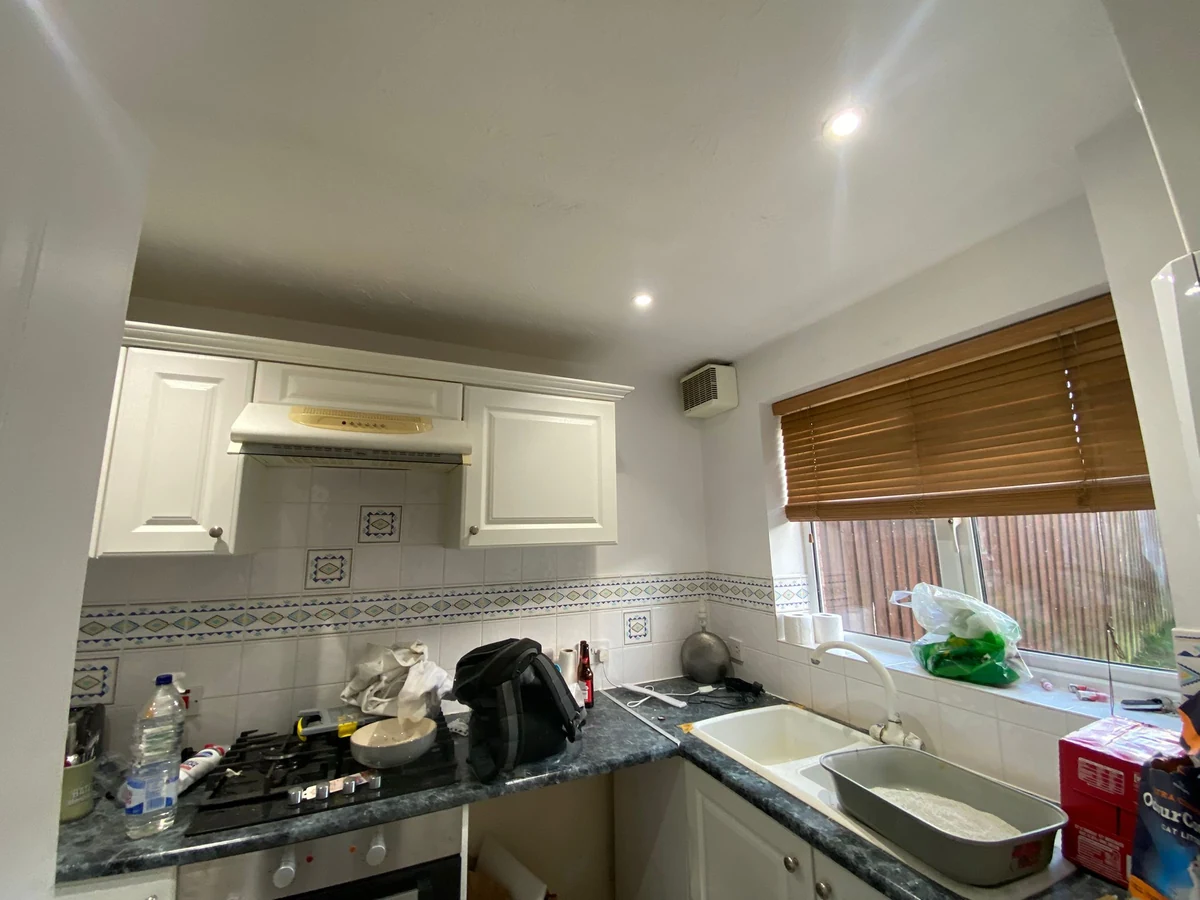 Kitchen with white cabinets and freshly painted ceiling, Swansea