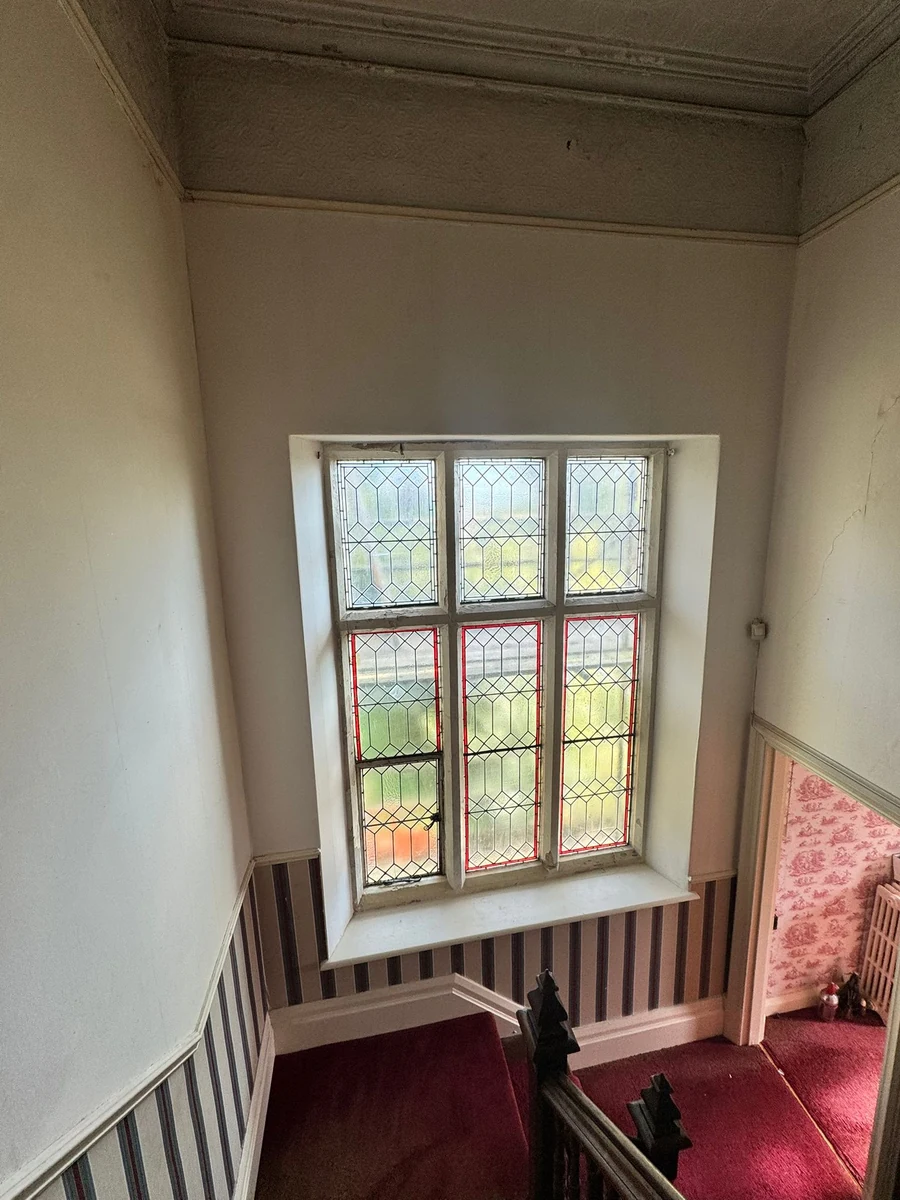 Repainted hallway wall around stained-glass window, Swansea